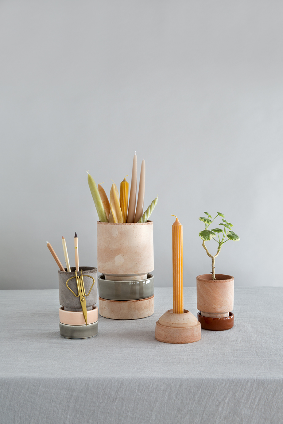 Raw rose candleholder, two raw rose pots with plants a raw grey pot with pencils and a mix of saucers.