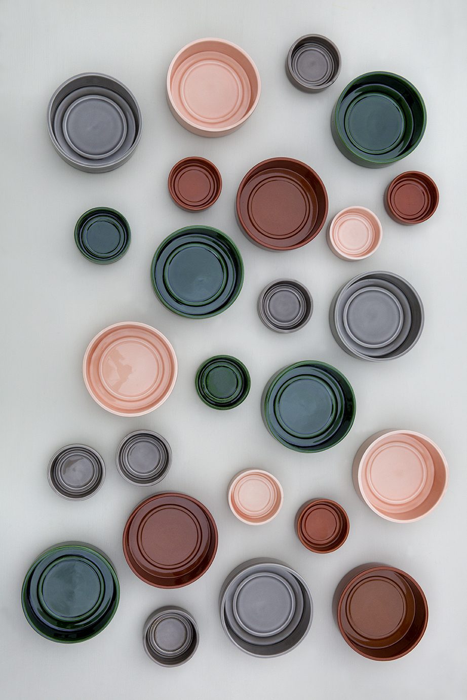 Collection of raw and glazed saucers in different colors seen from above.