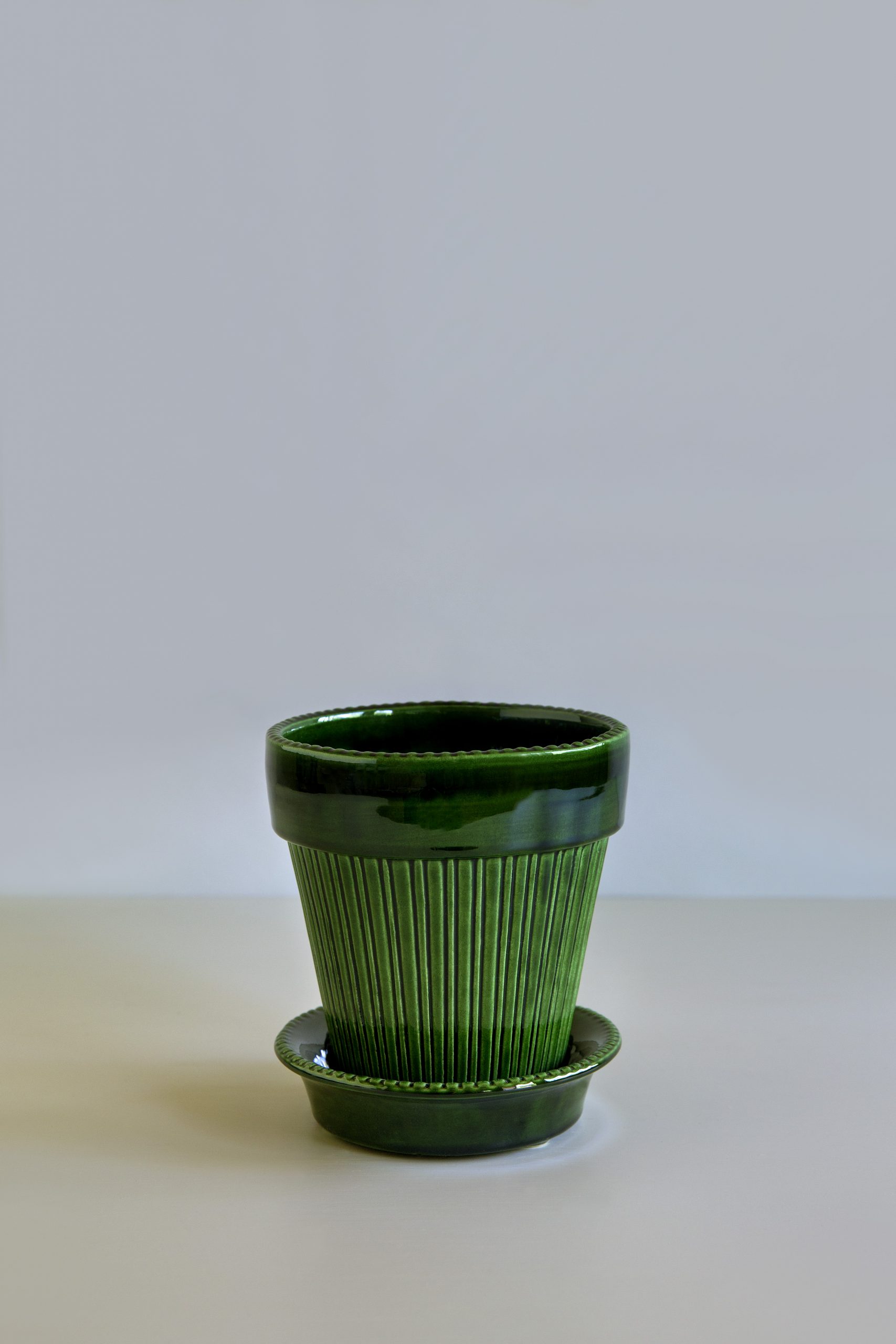 Glazed emerald green pot with saucer.