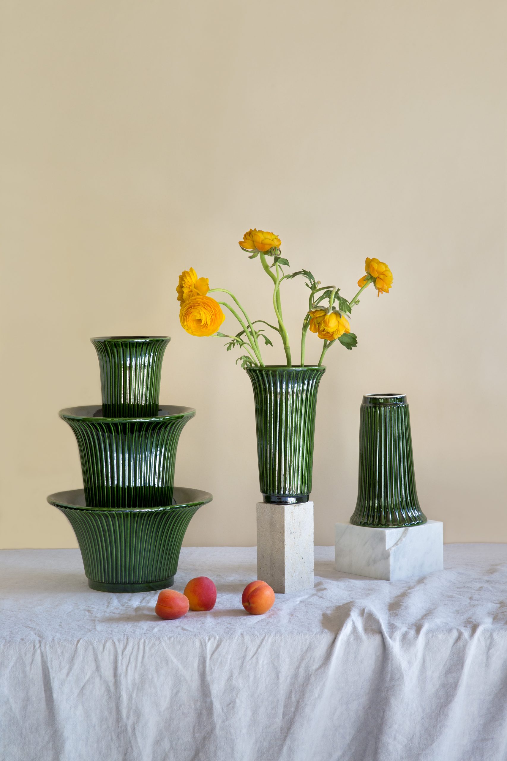 Collection of glazed green vases and standing pots arranged with flowers.
