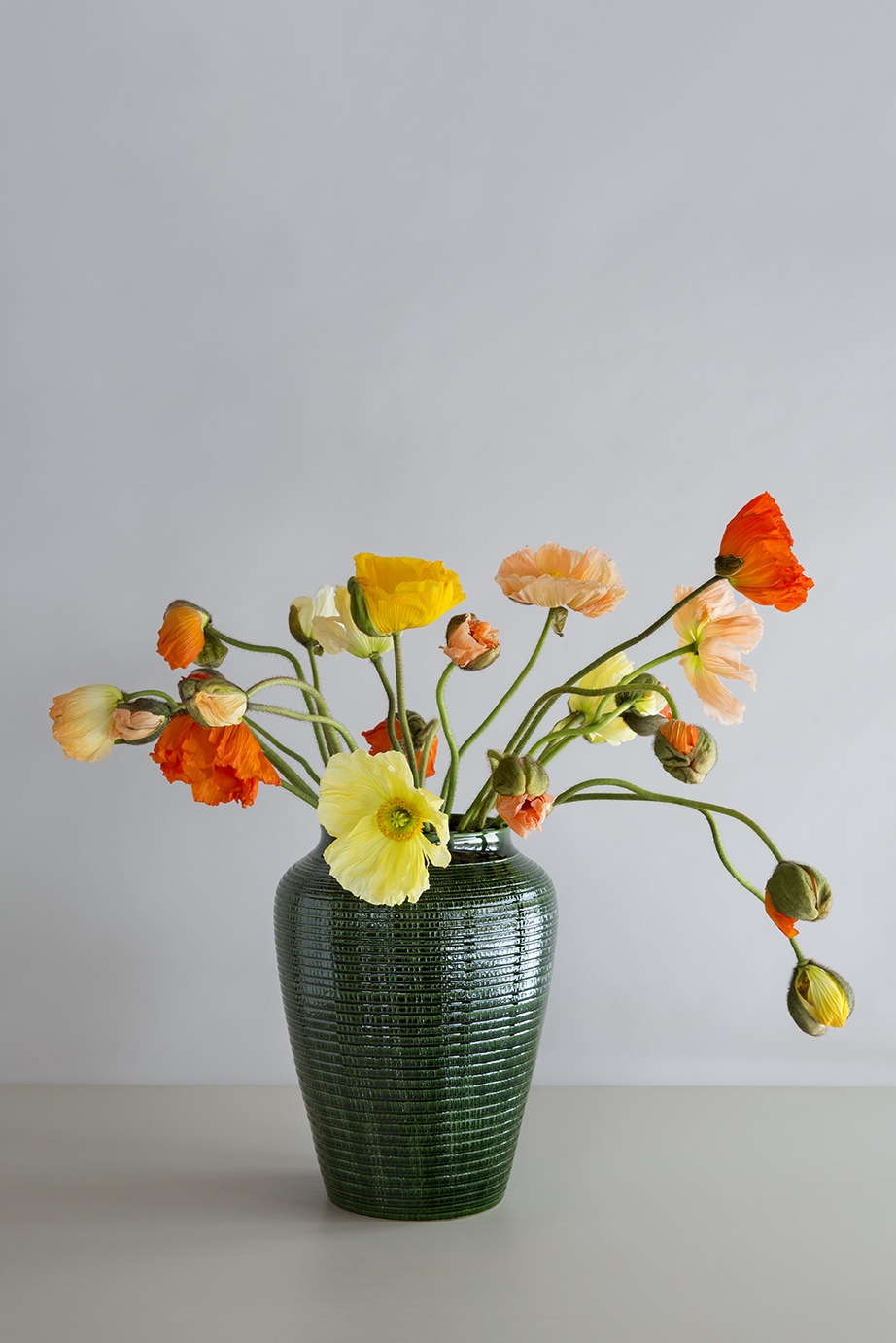 Green glazed vase with yellow and orange flowers