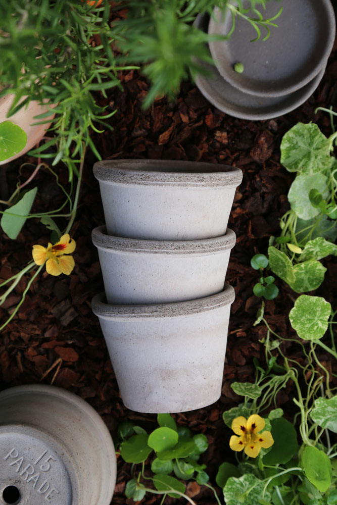 Stacked grey pots on garden soil