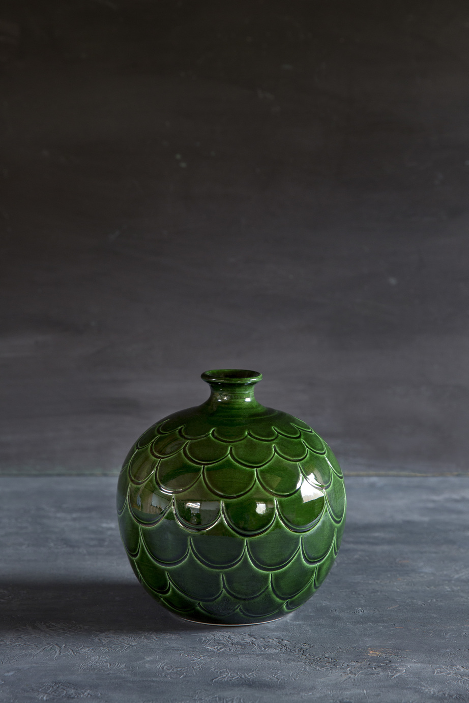 One green glazed round-shaped vase.