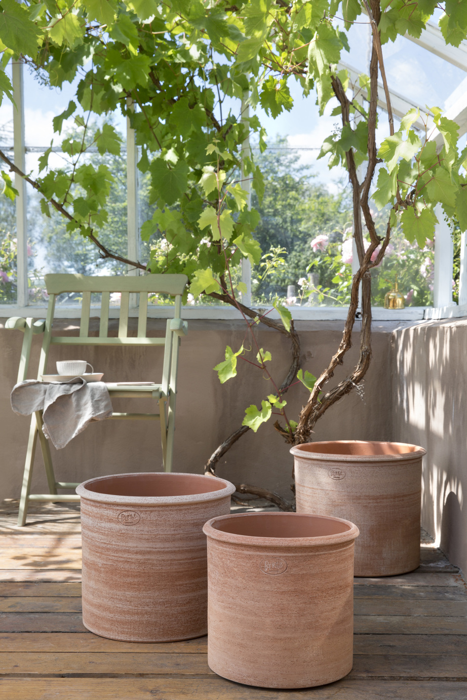 Three raw rose cylindrical outdoor pots.