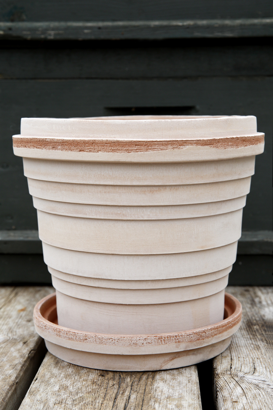 Raw rose terracotta pot made of layered rings in different sizes.