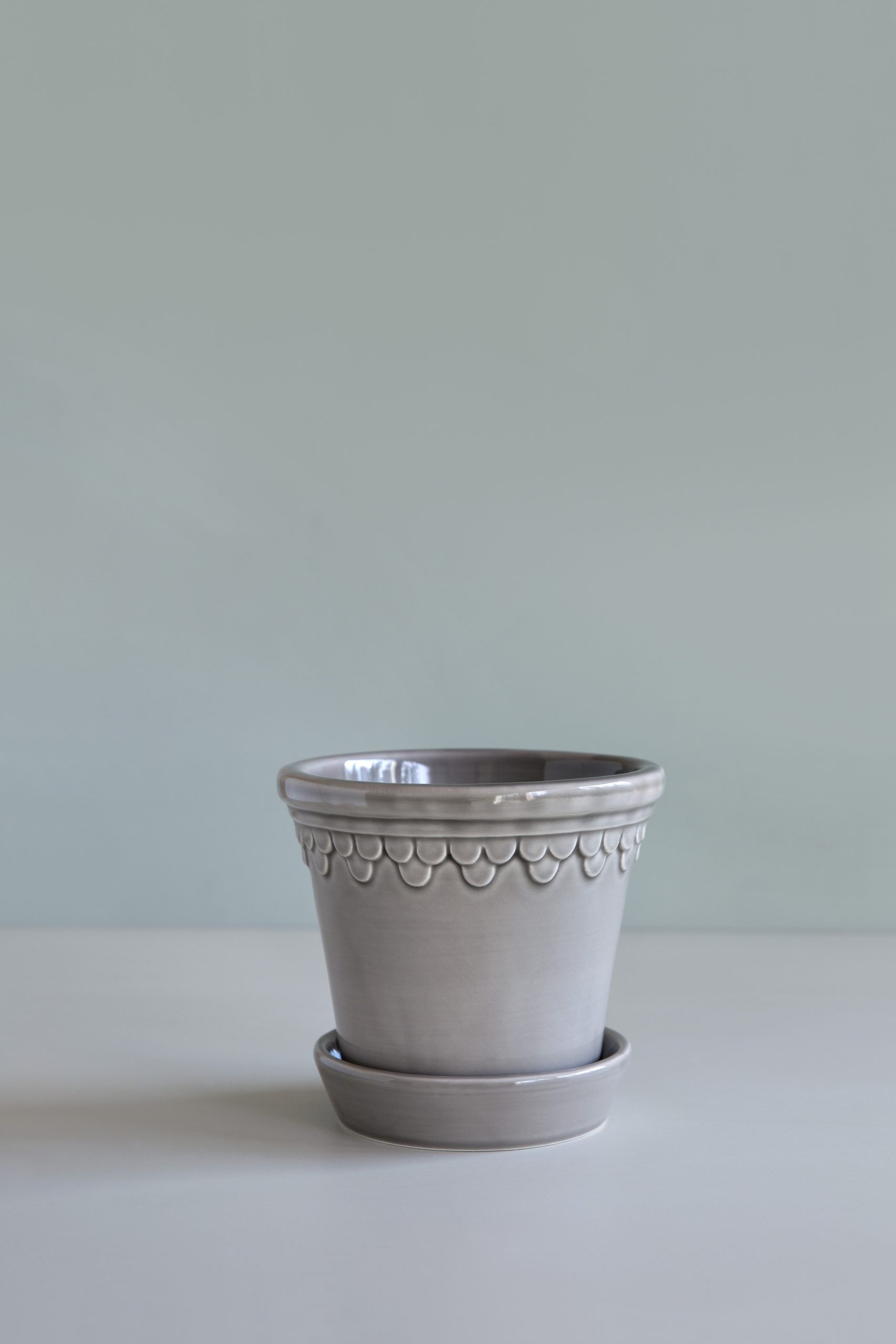 Glazed pearl grey pot with saucer.