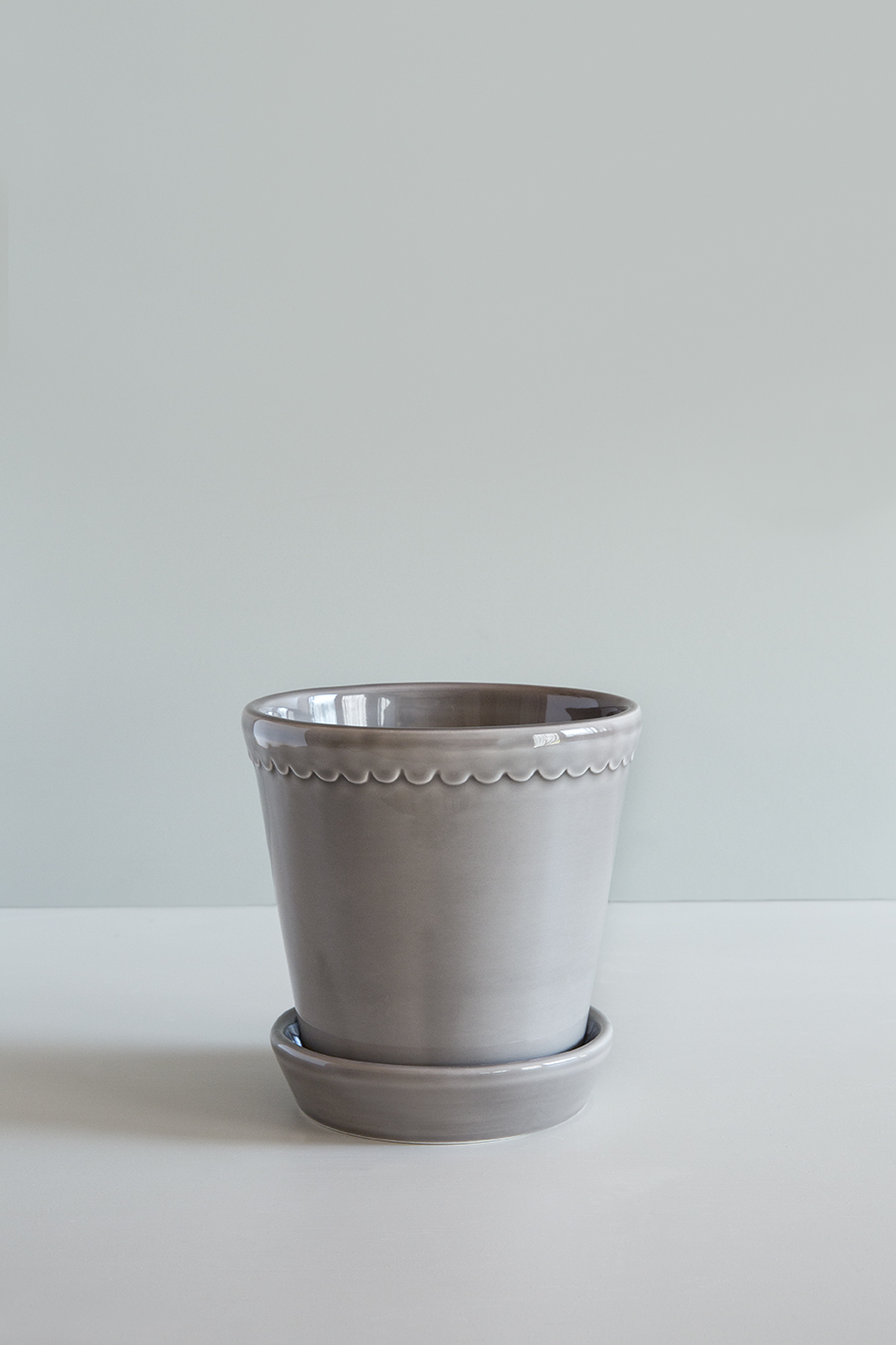 Glazed pearl grey pot with saucer.