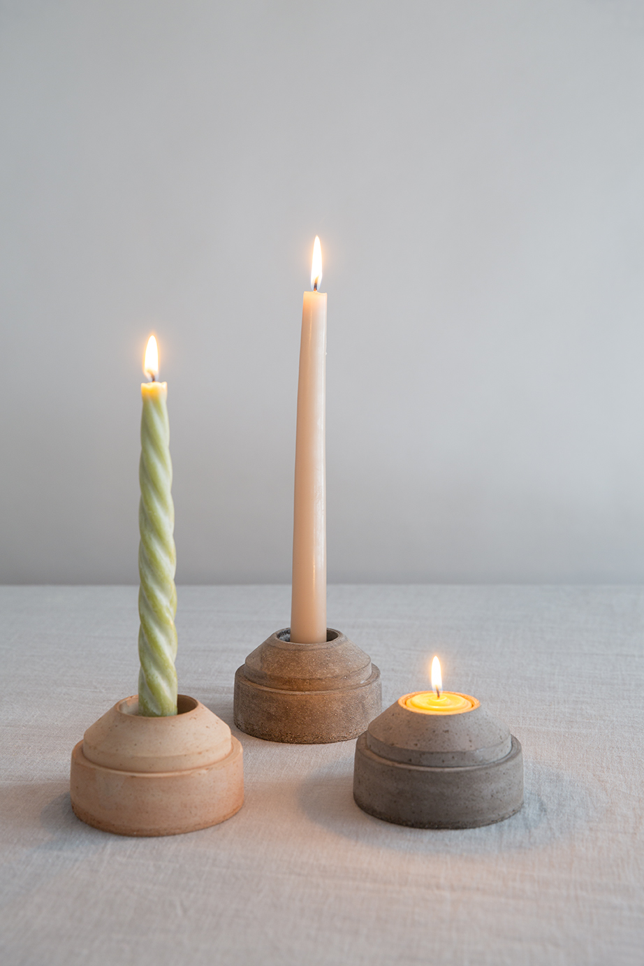 Three raw candleholders with candles.