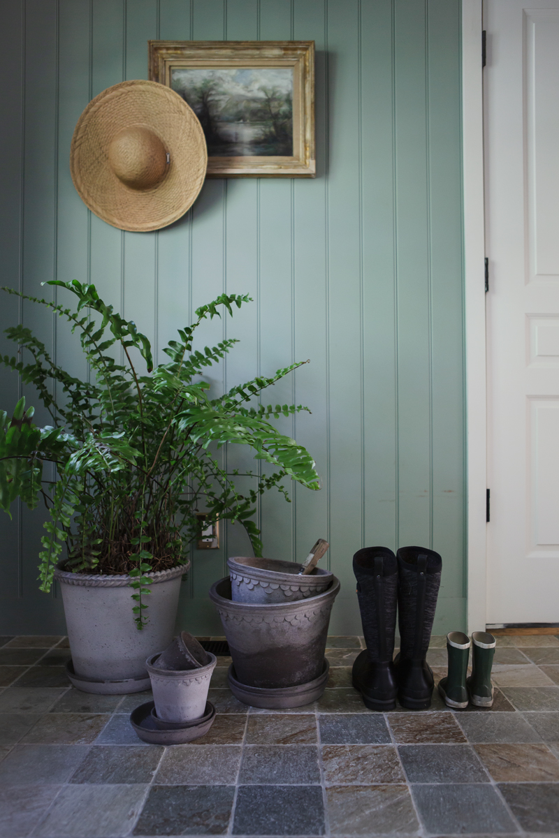 Emilia pot Ø35 cm by Bergs Potter in Nordic grey with a beautiful Boston Fern. Next to the wellies, Copenhagen by Bergs Potter Ø30 and Ø25 cm, in front: Copenhagen by Bergs Potter Ø18 cm with Helena by Bergs Potter Ø10 cm stacked inside. All pots in Nordic grey premium terracotta. Photo: Krissy O'Shea.