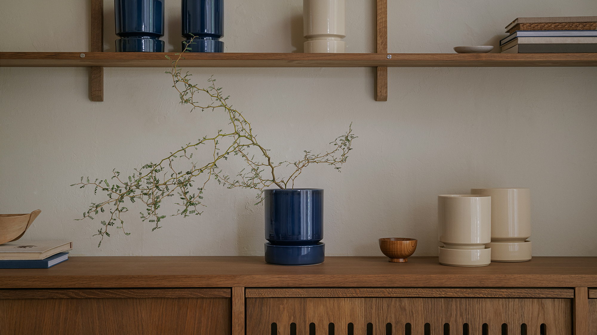 Bergs Potter Hoff Sandstone set and sapphire blue set on a shelf.