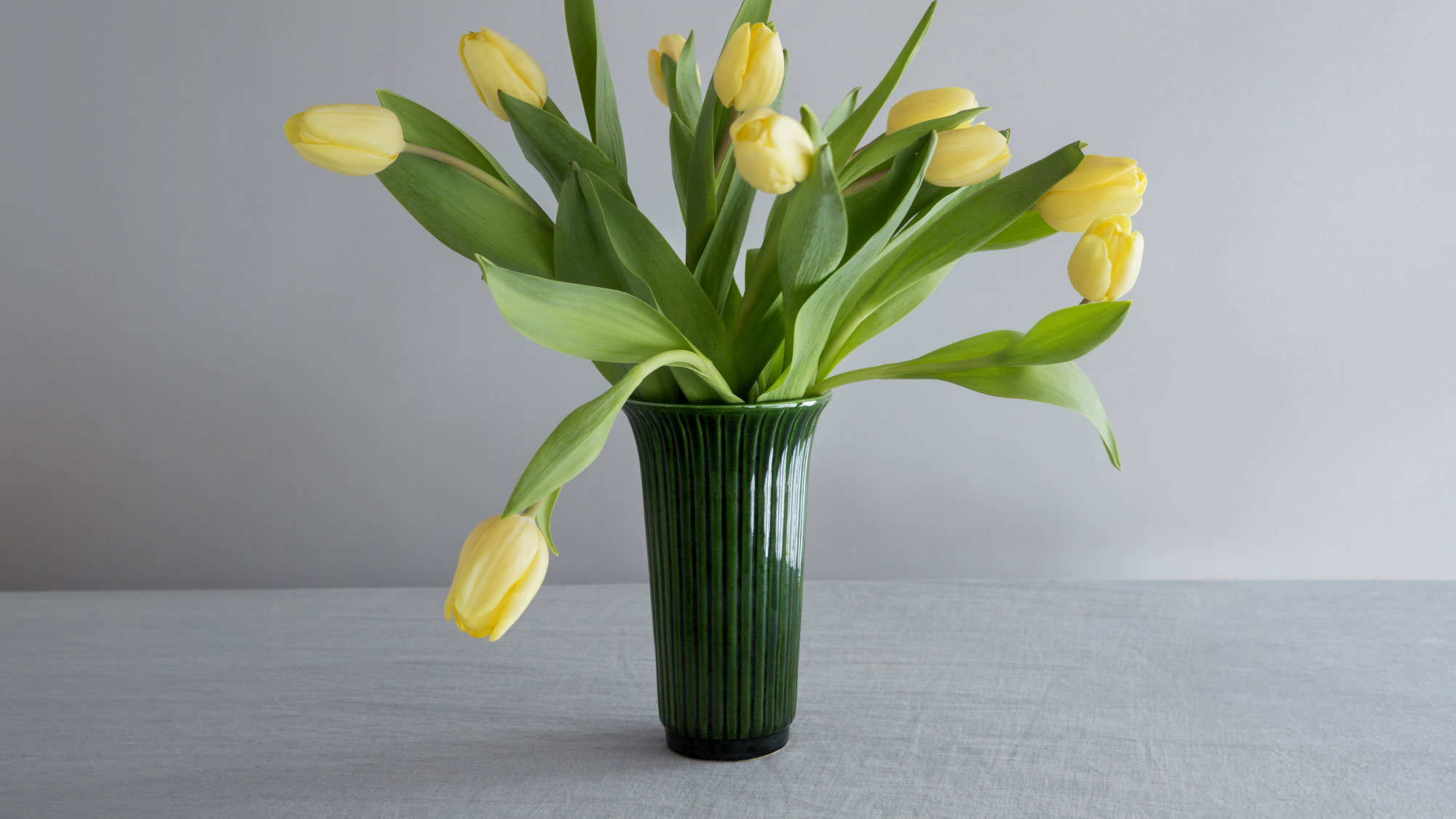 Bergs Potter emerald green Daisy vase with yellow tulips