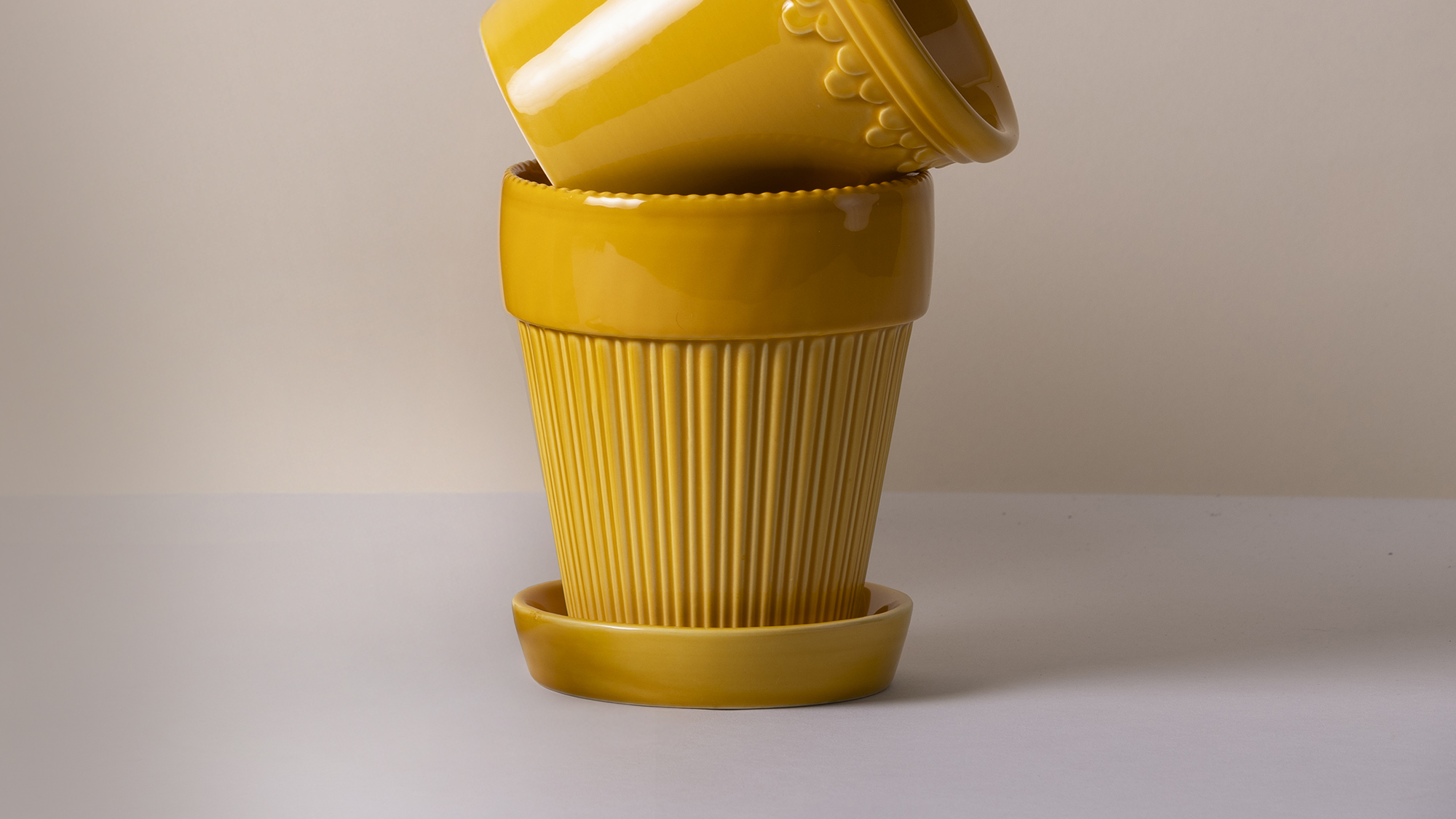 Bergs Potter amber yellow glazed ceramic plant pot with saucer.