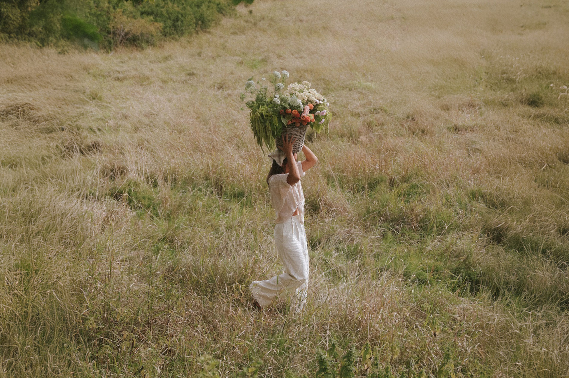 Anna Kubel carrying garden flowers in summer meadow