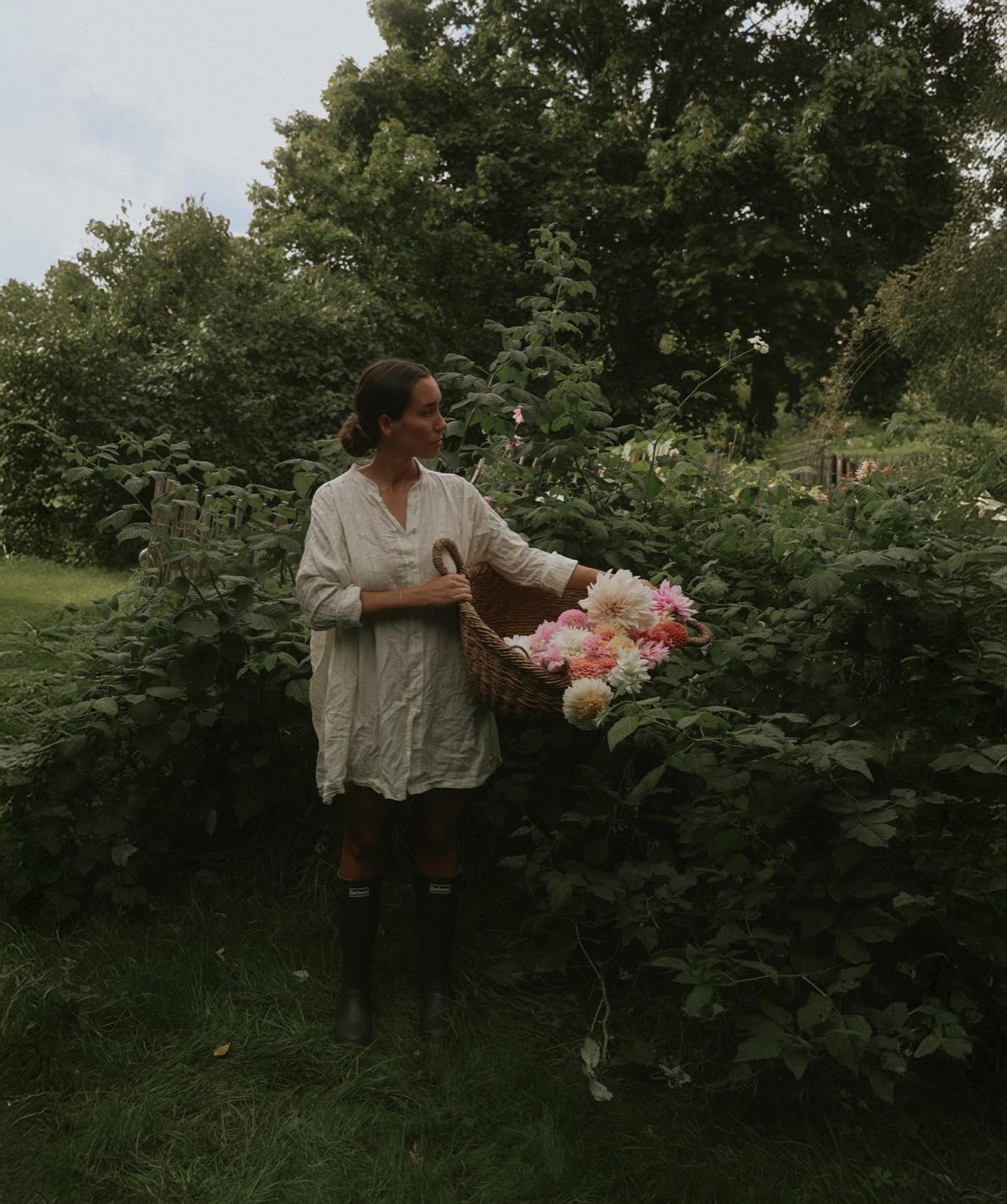 Anna Kubel picking garden flowers with harvest basket