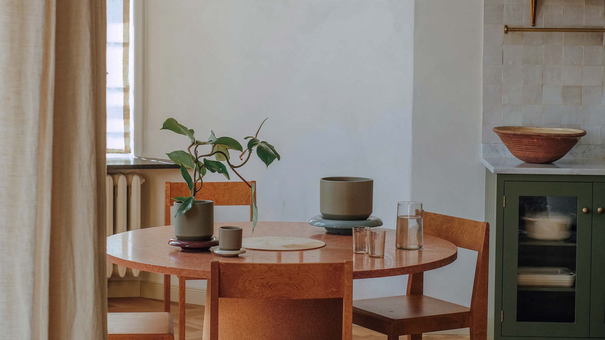 Dining room with Bergs Potter Lily pots in soft green glaze on round wooden table