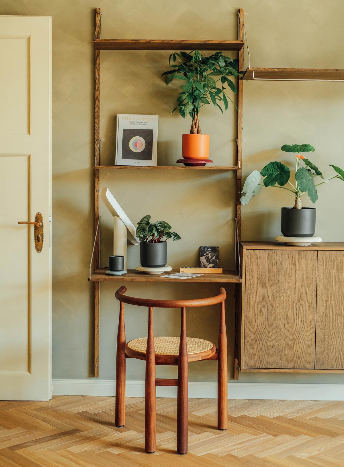 Bergs Potter Lily pots in tangerine orange with burgundy saucer and forest night with sandstone saucer styled on shelving