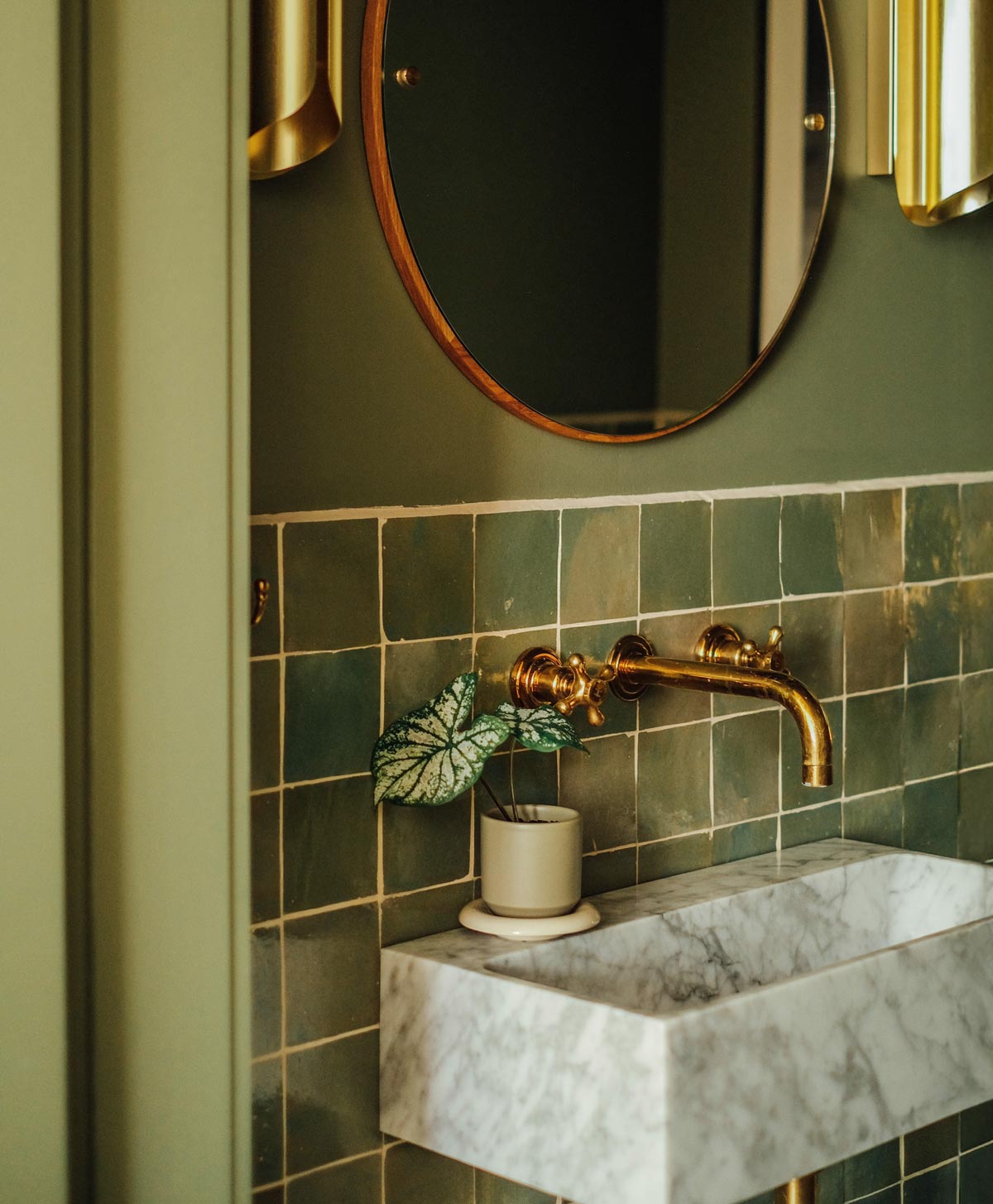 Sage green Bergs Potter Lily pot with sandstone saucer on bathroom sink