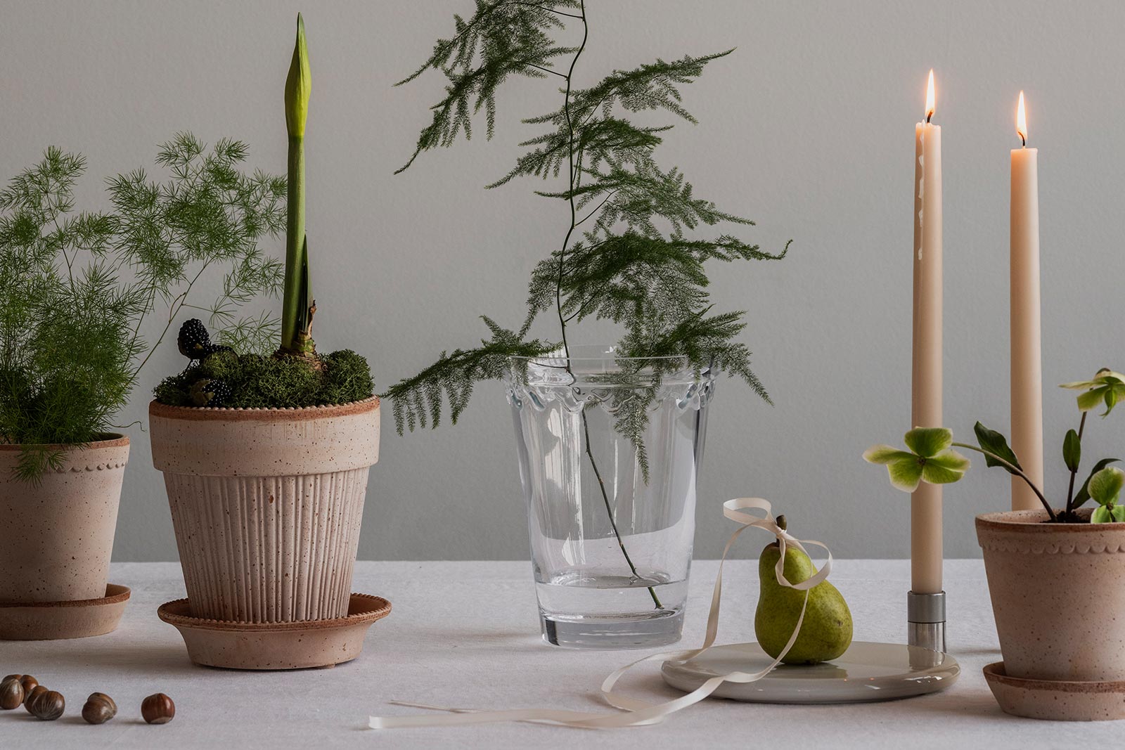 Holiday table setting with Bergs Potter terracotta pots, candles, and greenery