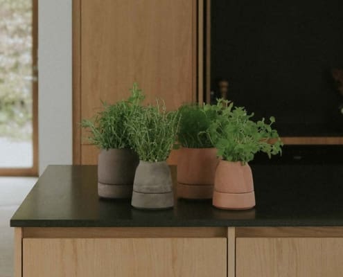 Bergs Potter Viva herb pots on a kitchen island in rosa and grey terracotta.